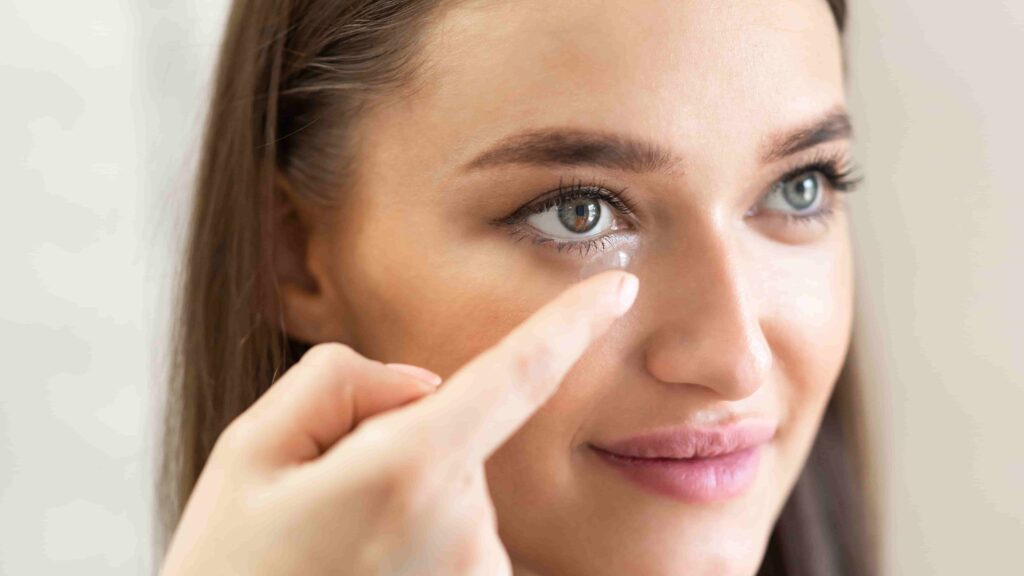 Close-up of a person inserting a contact lens